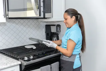 merry maid cleaning the glass microwave tray